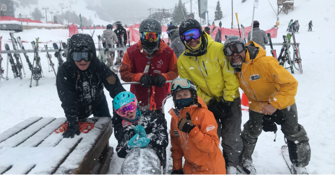 Lucy and her family pose for a picture on the ski slopes.