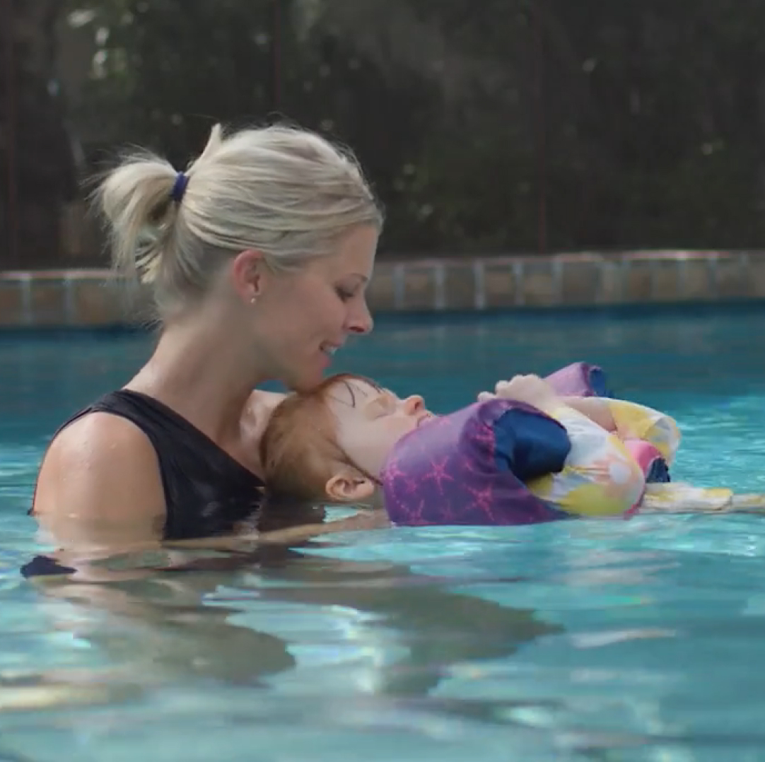 Caroline holding Minna in a pool.